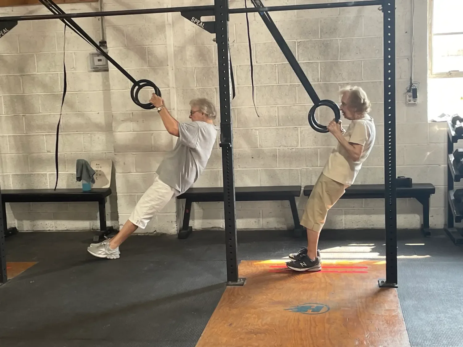 Two Senior Fitness members doing ring rows
