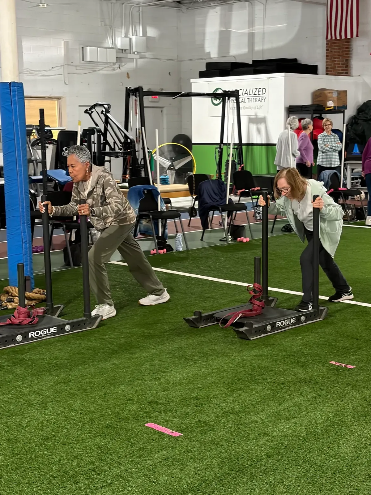 Senior Fitness members pushing sleds during a group class