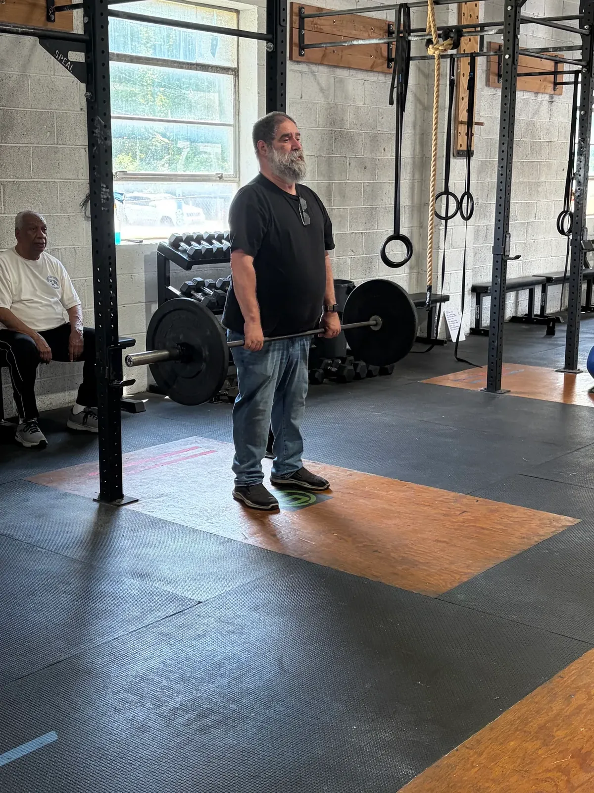A Senior Fitness member standing at a barbell