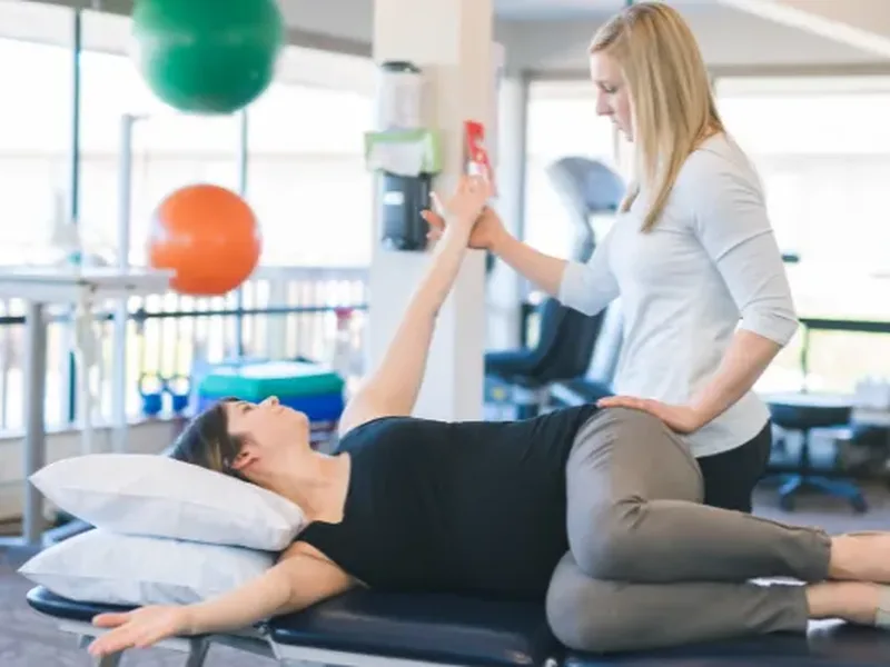 Physical therapist assessing a patient's hip movement and mobility