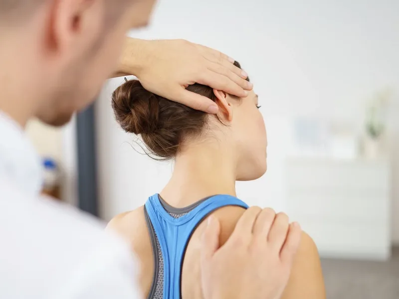 Physical therapist assessing a patient's neck and back after a motor vehicle accident