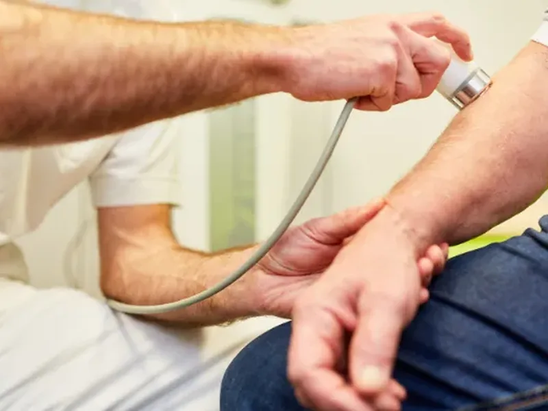Physical therapist assessing a patient's elbow and wrist movement